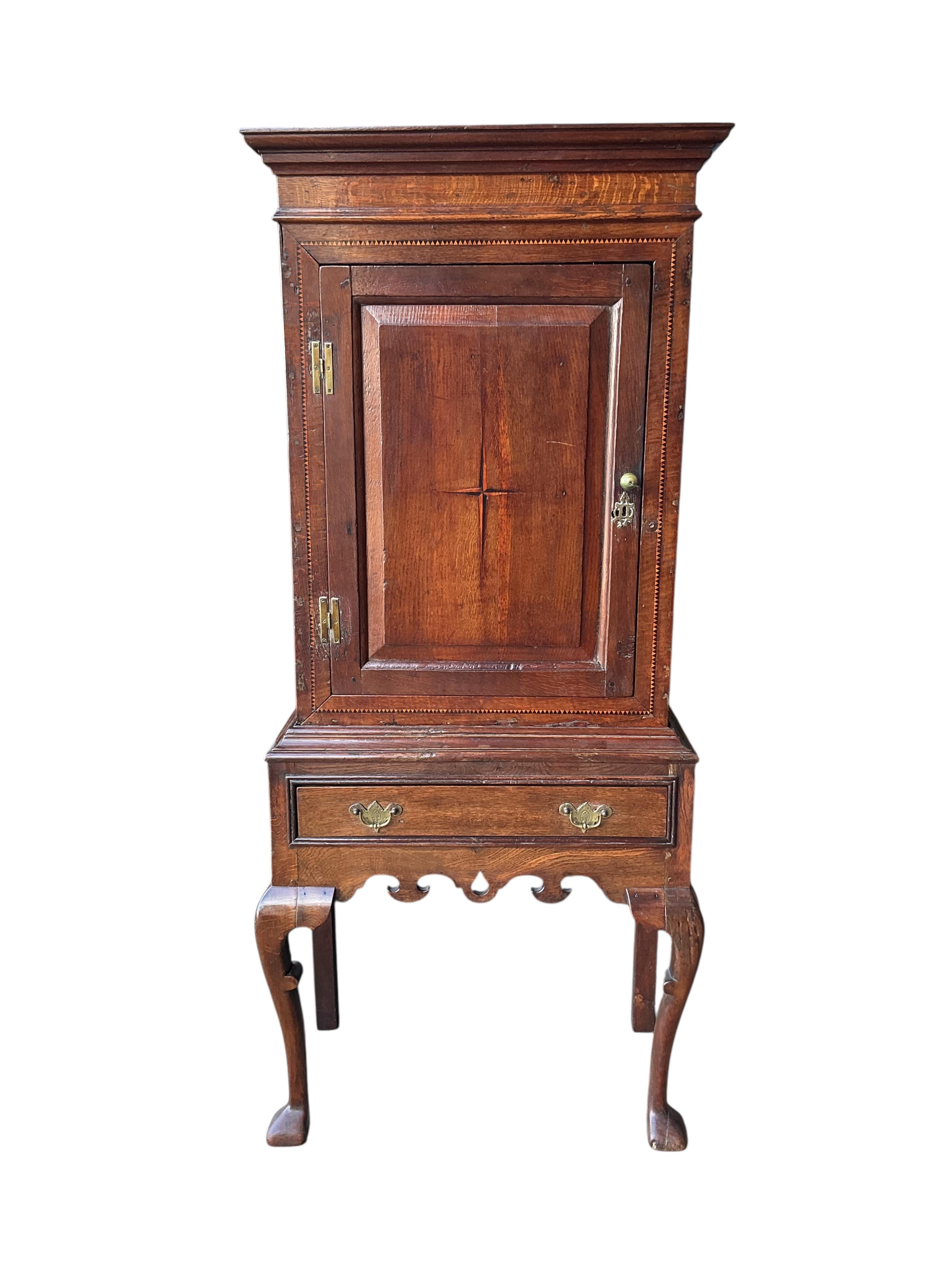 An 18th century and later inlaid oak cabinet on stand, width 72cm, depth 36cm, height 162cm